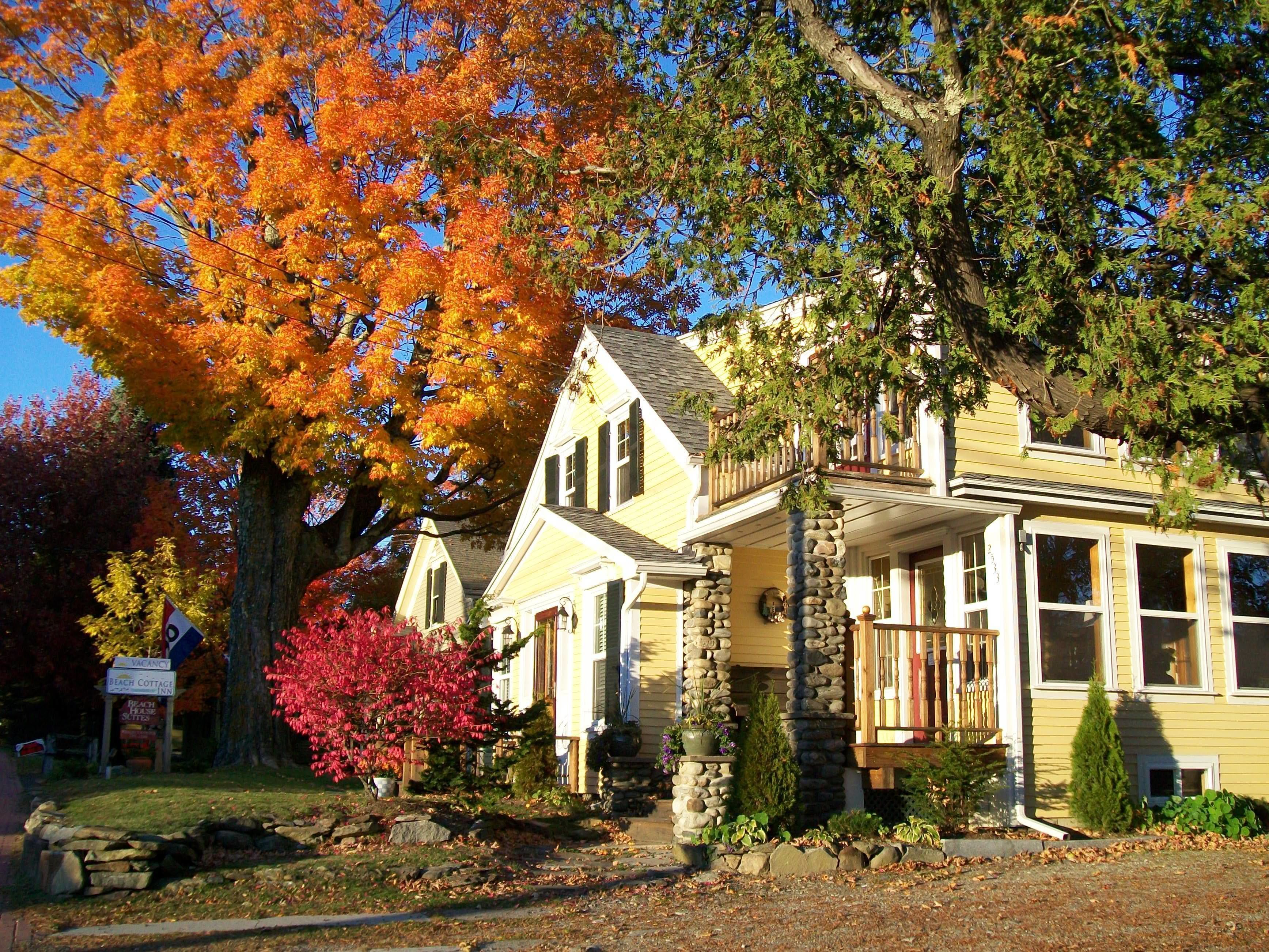 A two-story house with a stone foundation and a porch.