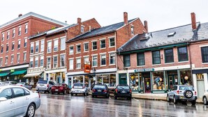 A street view with multiple brick buildings, including a shoe store and a general store. - Harkness Brook Inn (Rockport)