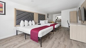 A hotel room with two beds, a desk, and a TV. - Harkness Brook Inn (Rockport)