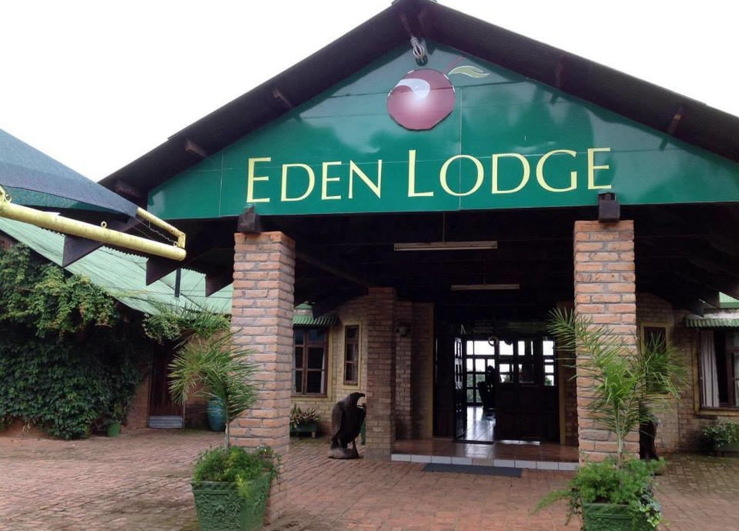 L’entrée de l’Eden Lodge, avec un panneau vert et un grand logo rouge.
