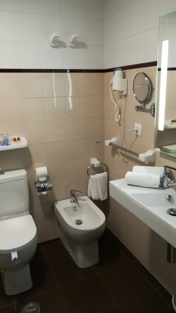 A bathroom with a toilet, bidet, and sink.