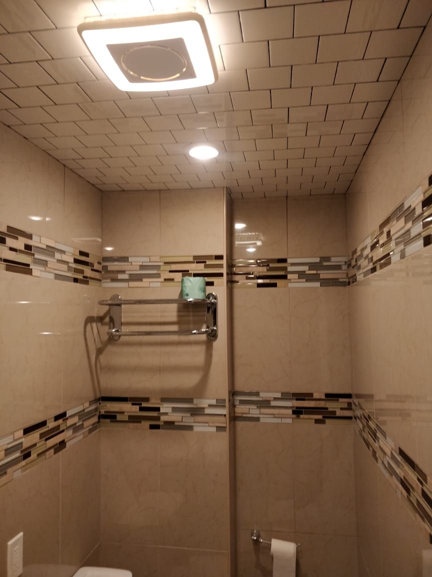Une salle de bain moderne avec un carrelage au sol, une douche en verre et un porte-serviettes.