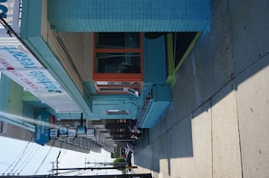 A hotel with a blue facade, a visible entrance, and a sign indicating it is a beachside resort office.