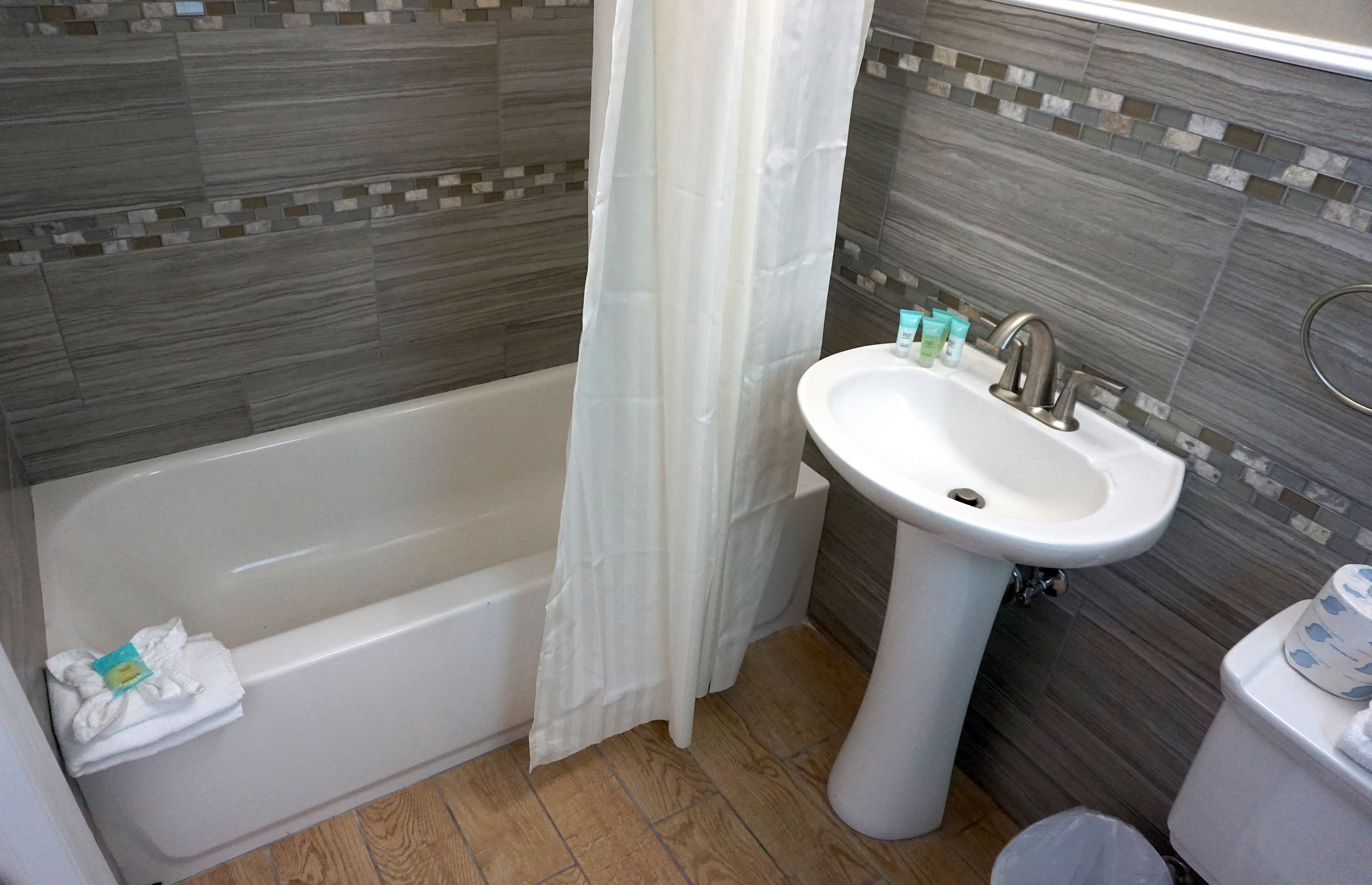 A bathroom with a bathtub, a sink, and a toilet.