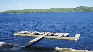 Un quai où sont amarrés plusieurs bateaux et une jetée en bois qui s’avance dans une vaste étendue d’eau.