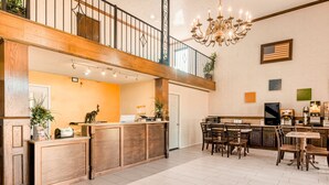 Un'ampia cucina con isola in legno, un'area pranzo con tavolo e sedie, e una scala che conduce a un piano superiore.
