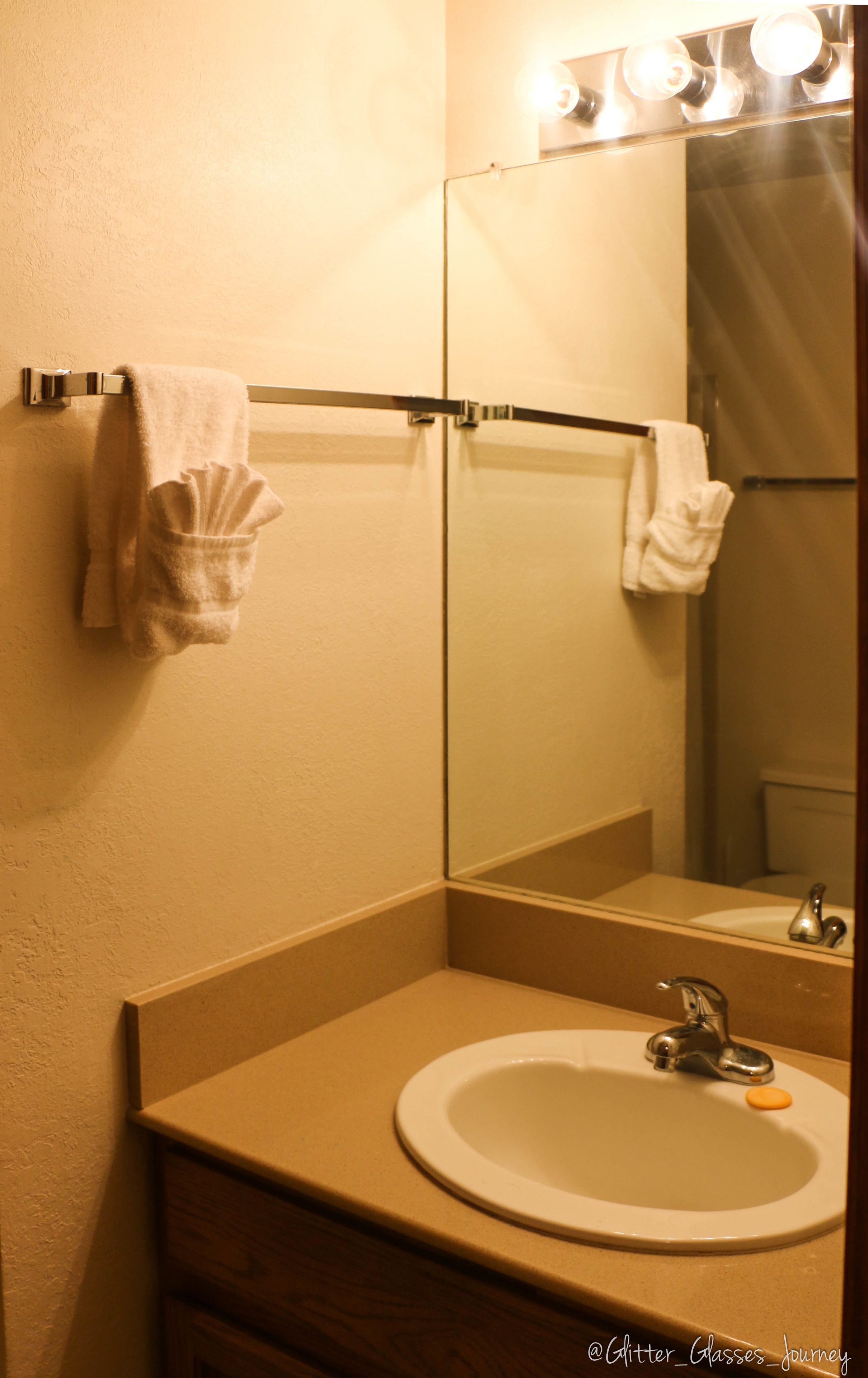 Une salle de bain équipée d’un lavabo, d’un miroir et d’un porte-serviettes.