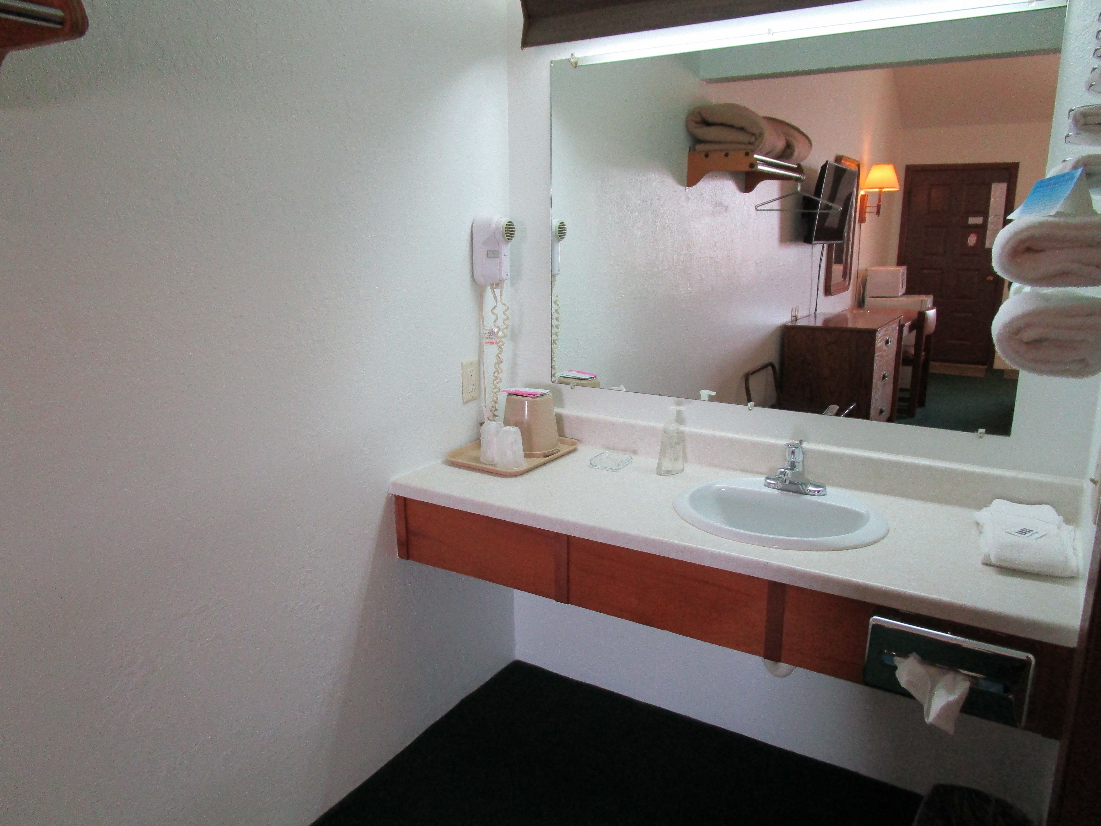 A bathroom with a sink, mirror, towel rack, and a hanging towel.