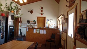 L’intérieur d’un restaurant est agrémenté d’un plafond en bois, d’un comptoir doté d’une porte en bois et de diverses décorations murales, notamment des têtes d’animaux montées sur des supports.