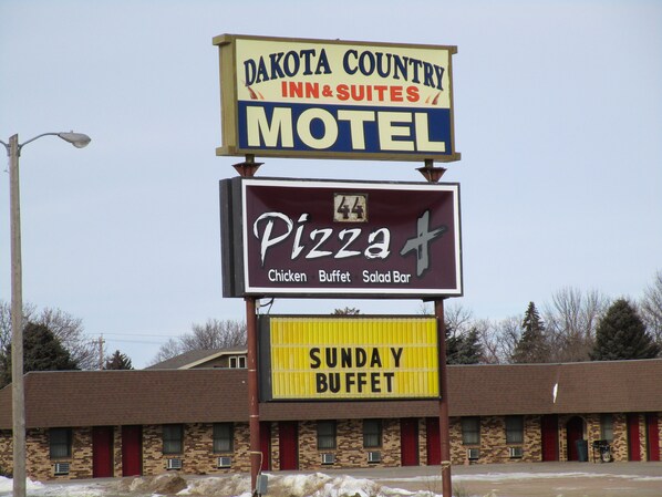 Segnaletica di motel con ristorante pizzeria e cartello per il buffet della domenica.