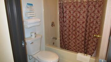 A bathroom with a toilet, a shower curtain, and a towel rack.