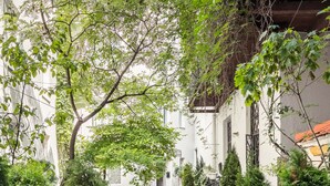 A courtyard with potted plants, a tiled floor, and a staircase leading to an upper level. - Platinia Apartments (Kraków)
