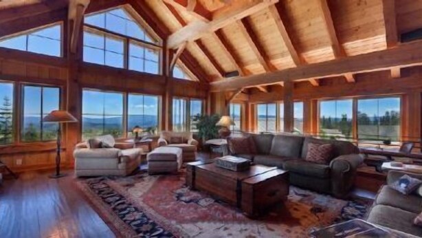 A spacious living room with a high ceiling and large windows offering a view of the outdoors. - Glacier Luxury Lodge (Truckee)