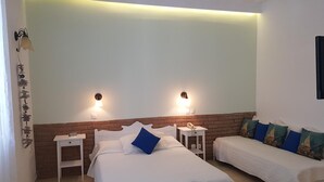 Ein Hotelzimmer mit zwei Einzelbetten, einem kleinen Nachttisch mit Lampe und einer Wand mit Ziegelverkleidung.