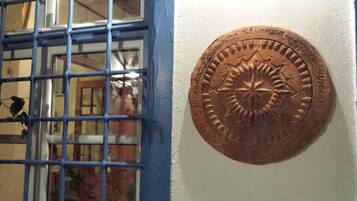 A window with blue bars and a brass plaque on the wall.