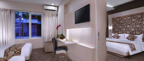 Une chambre d’hôtel avec deux lits, un bureau, une chaise, une télévision et une fenêtre avec des rideaux.