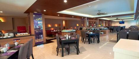 A hotel lobby with multiple seating areas, a reception desk, and a bar.