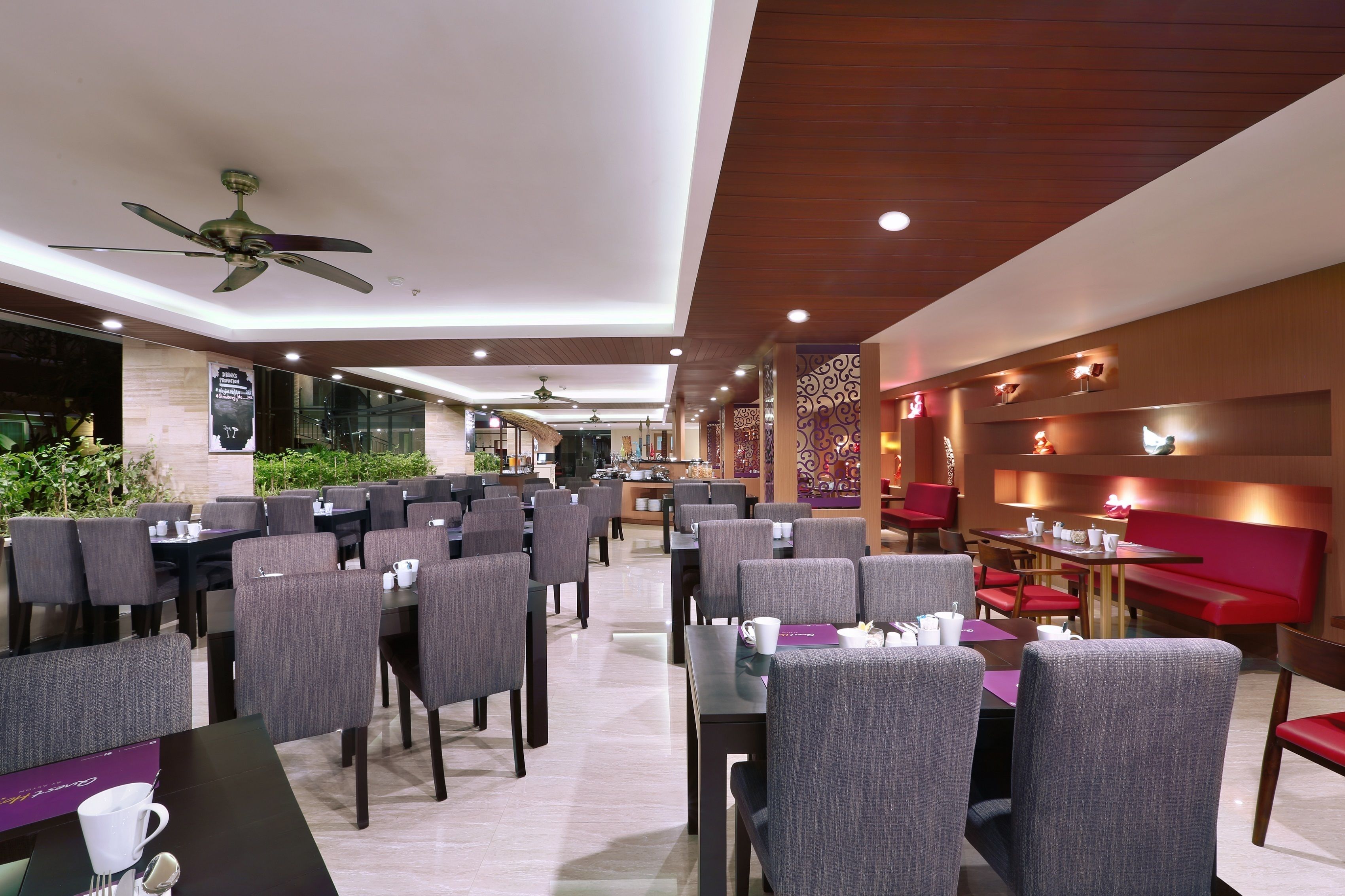 A modern restaurant with multiple dining areas, ceiling fans, and a variety of seating options including tables and booths.
