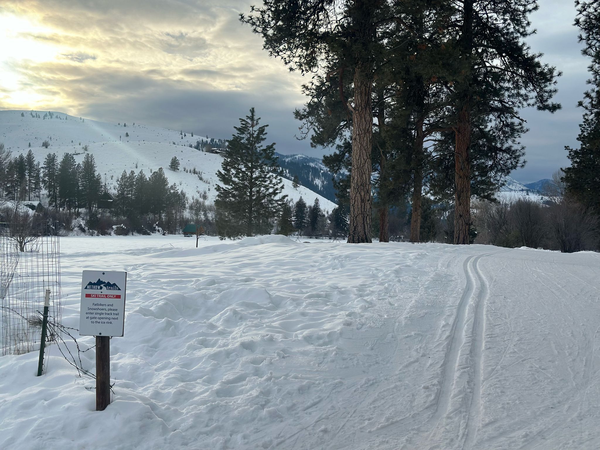 A snow-covered ski trail with a sign indicating it is for skiers only.