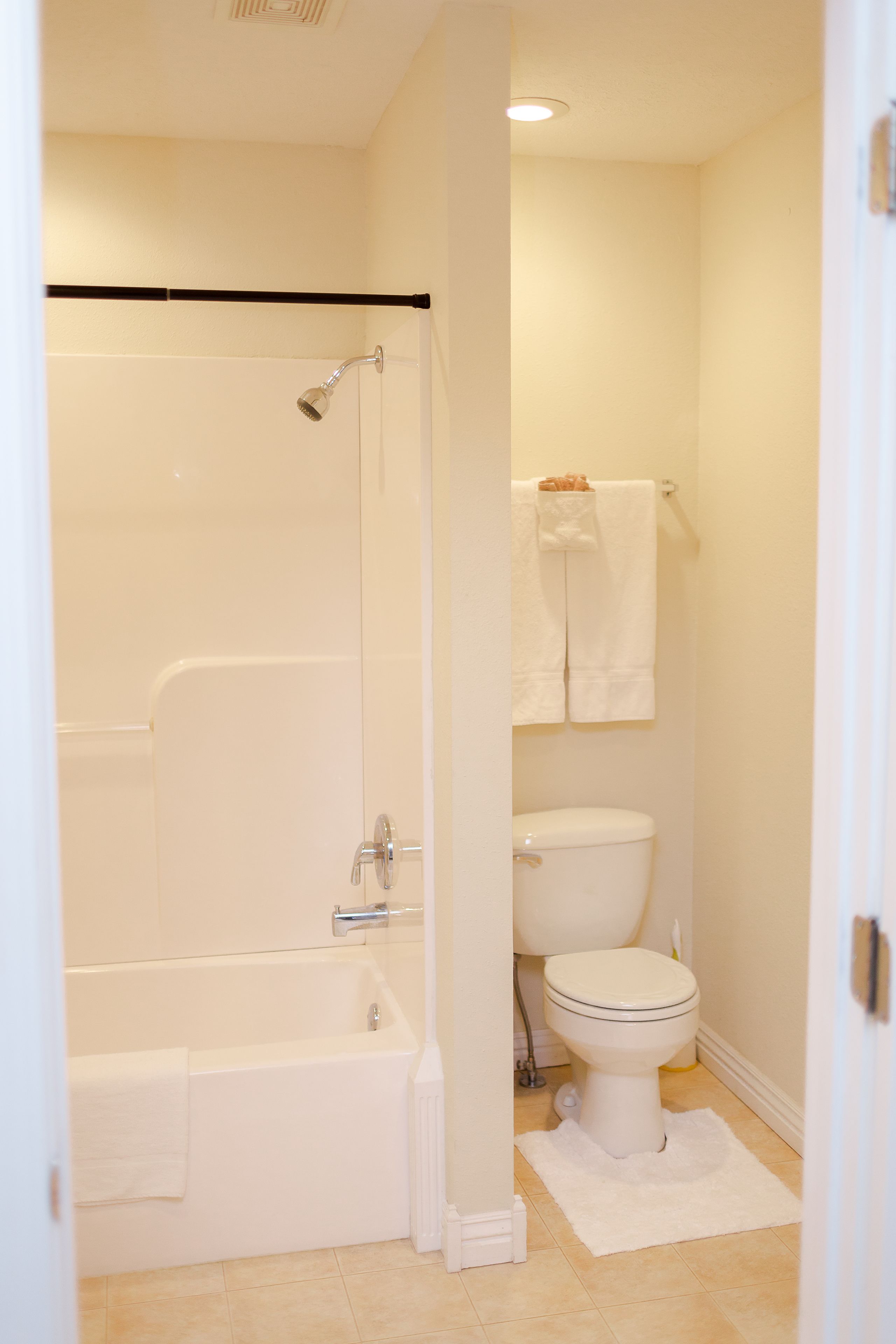 A bathroom with a bathtub, toilet, and a shower area.