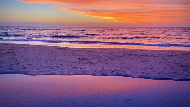 A beach with a sunset. - Atlantic West Beach Apartments (West Beach)