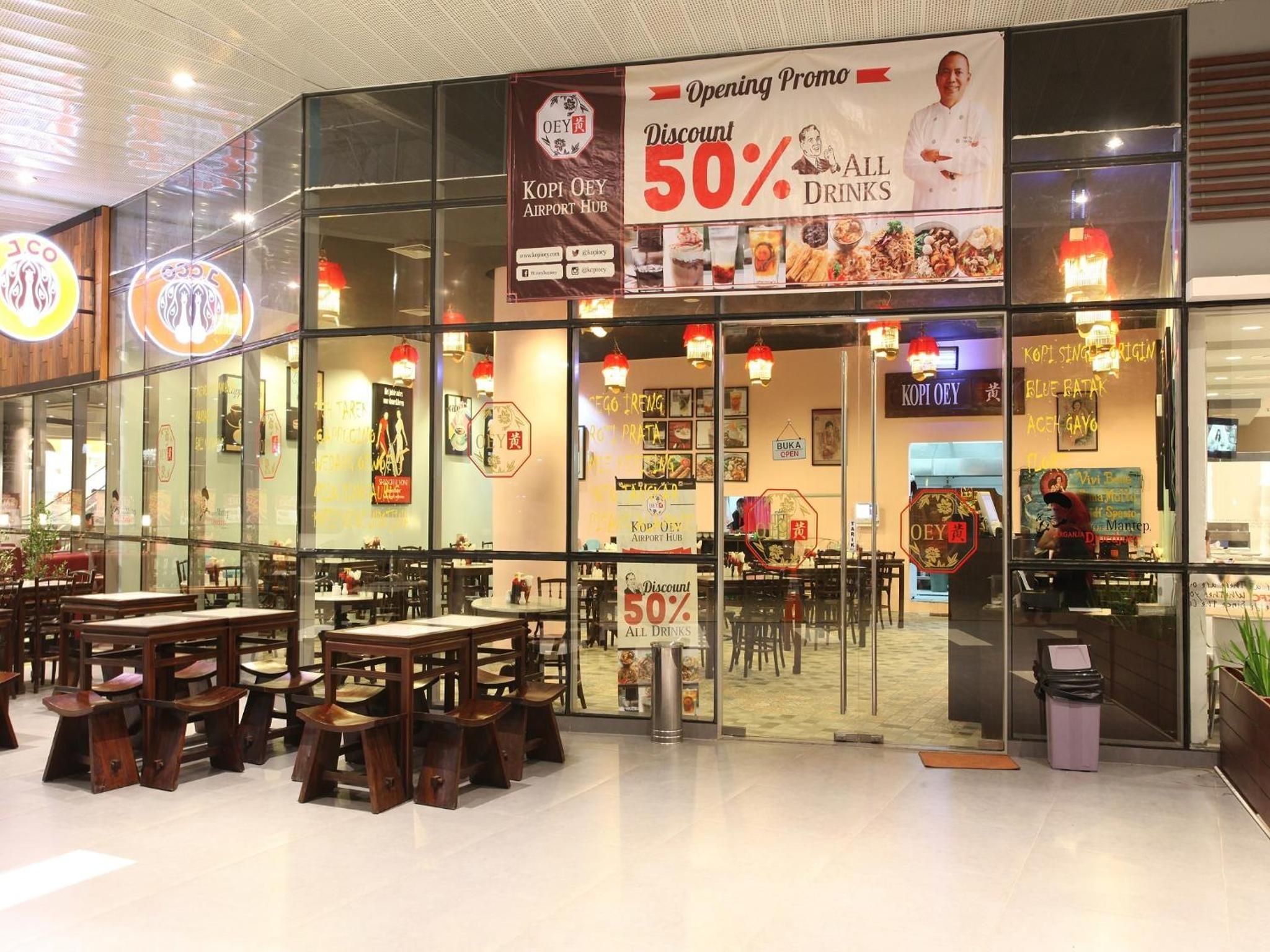 Un restaurant offrant une réduction de 50 % sur toutes les boissons, avec un intérieur moderne agrémenté de tables et de chaises en bois.