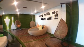 Relax in this stylish room with a large, curved bed and a hanging chair, offering a comfortable retreat.