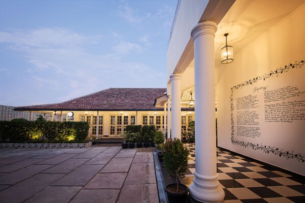 A building with a tiled roof, a checkered floor, and a wall with text.
