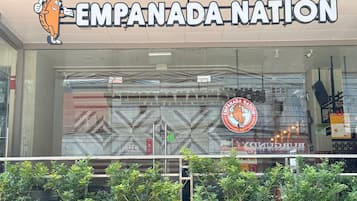 La devanture du restaurant Empanada Nation, avec une grande enseigne et une mascotte.
