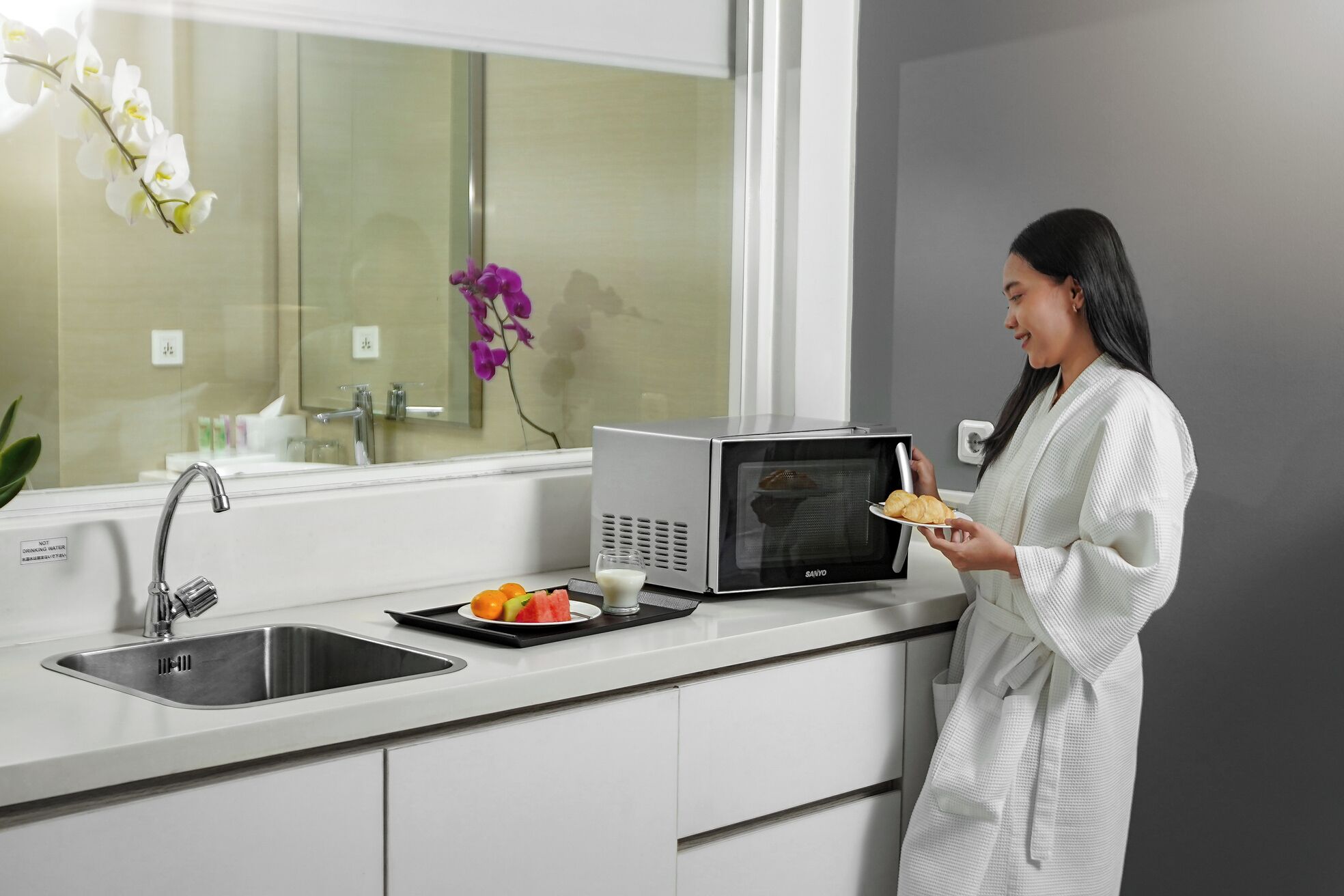A modern kitchen with a built-in microwave, a sink, and a window with a view.