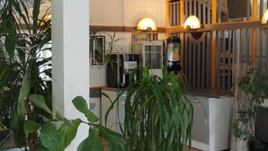 Une cuisine moderne équipée d’une machine à café, d’un réfrigérateur et de diverses plantes.