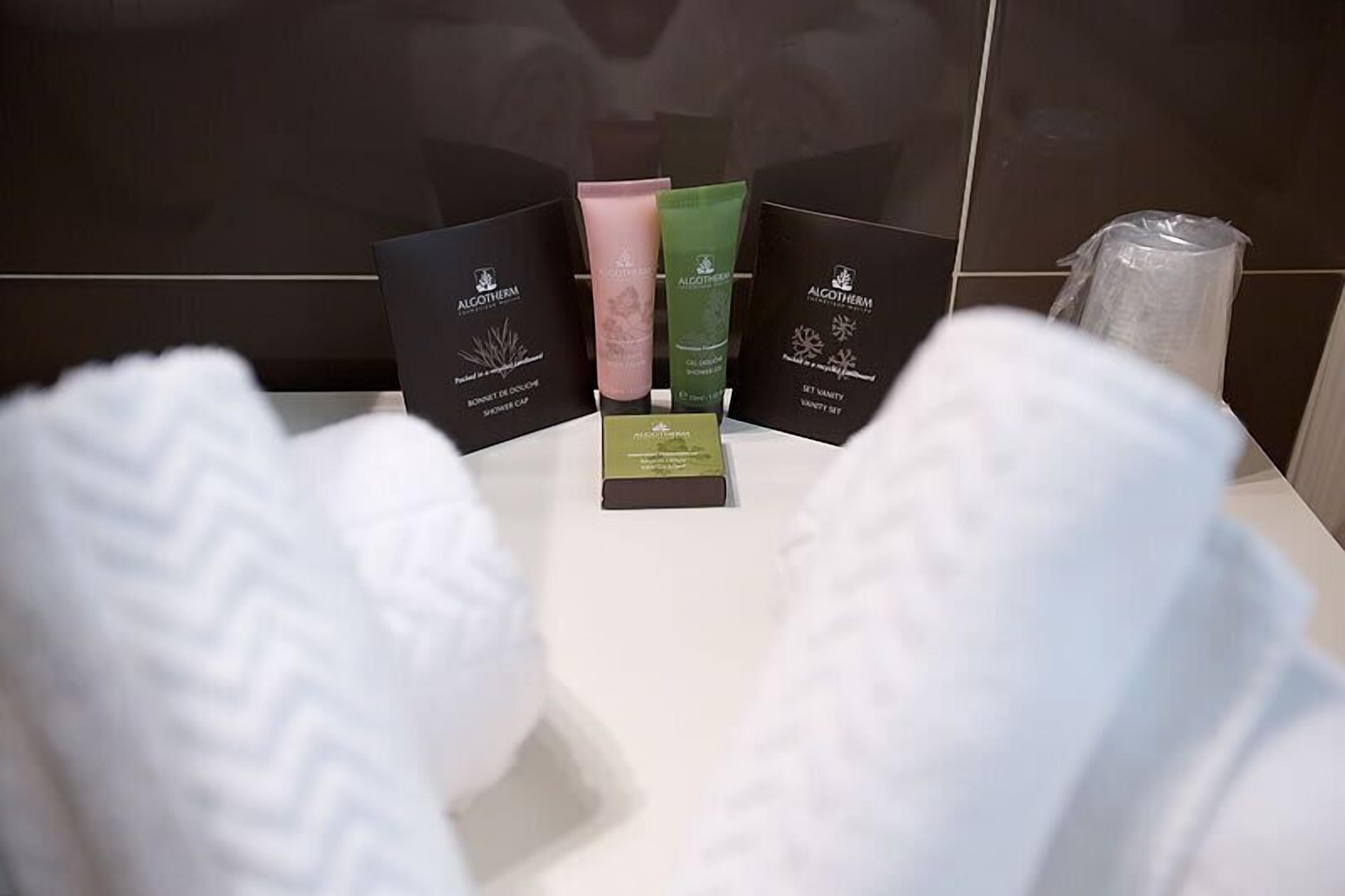 Un baño con artículos de aseo, que incluye un gorro de ducha, un set de limpieza facial y un juego de productos de tocador.
