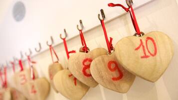 Una hilera de etiquetas de madera con forma de corazón y números, colgadas en una pared.