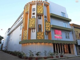Un hotel de diseño moderno, con una columna vertical destacada que presenta elementos decorativos y el letrero de 'LA WOODSEY HOTEL'.