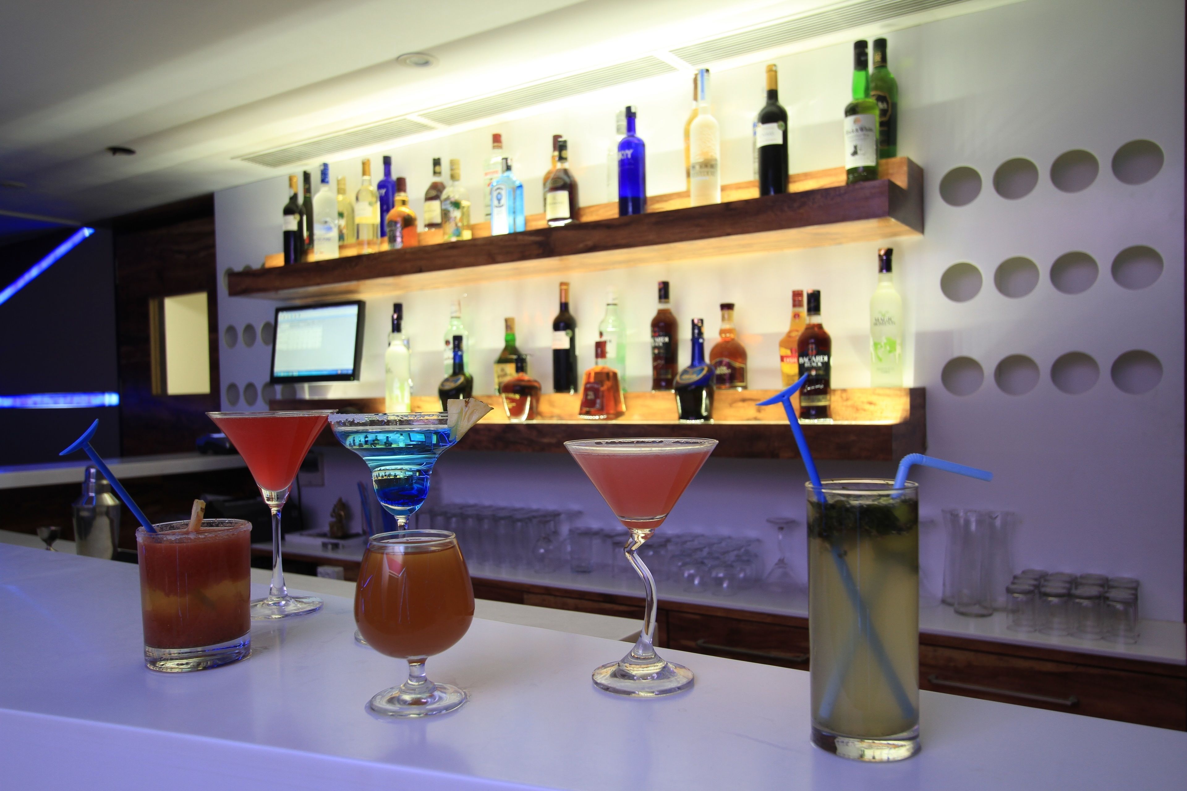 Un bar con diversas bebidas y botellas en estanterías.