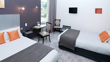 Une chambre d’hôtel avec deux lits, un bureau, une chaise et un téléviseur.