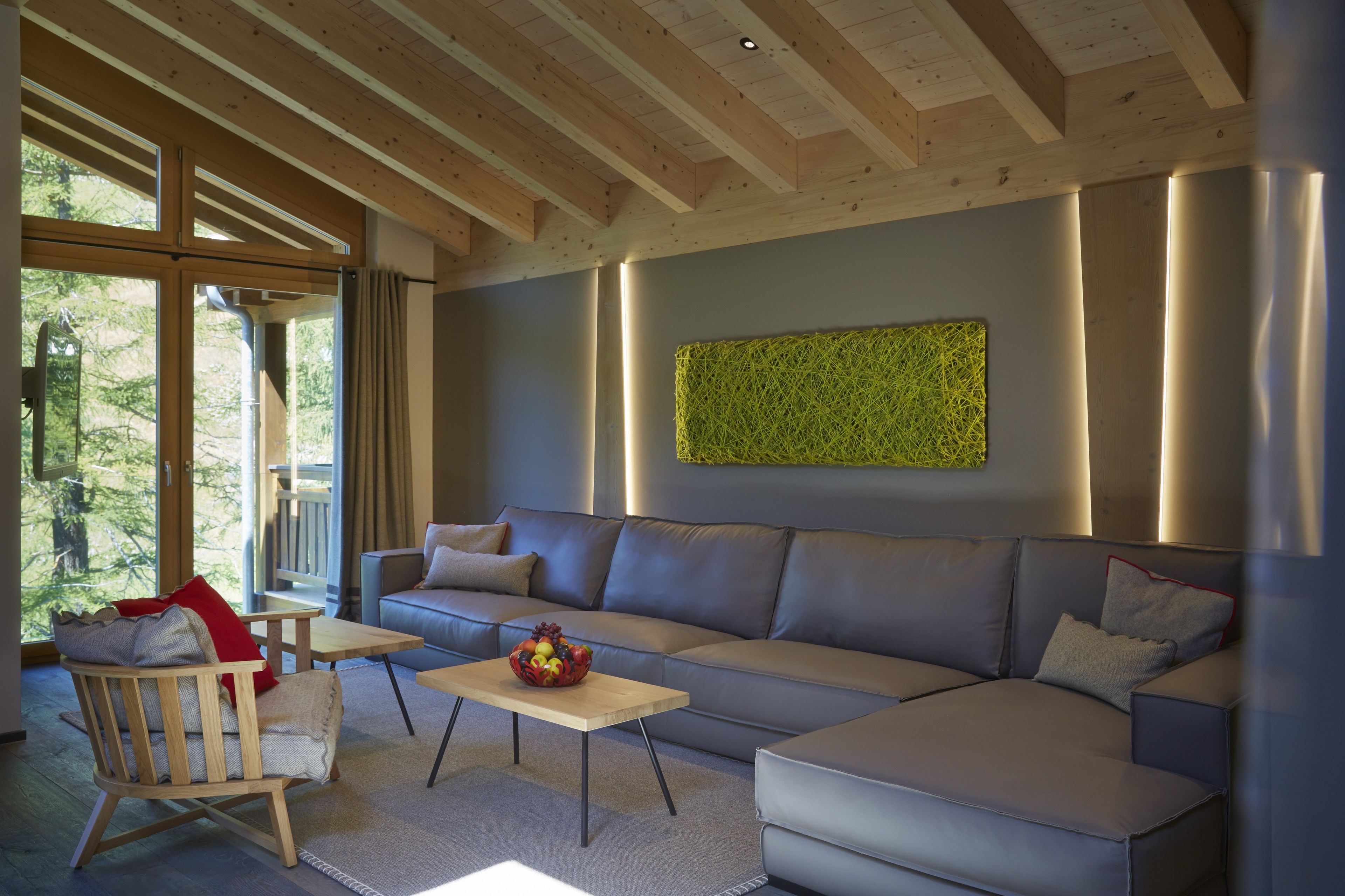 Un soggiorno moderno con un divano grigio, un tavolino in legno e una poltrona.