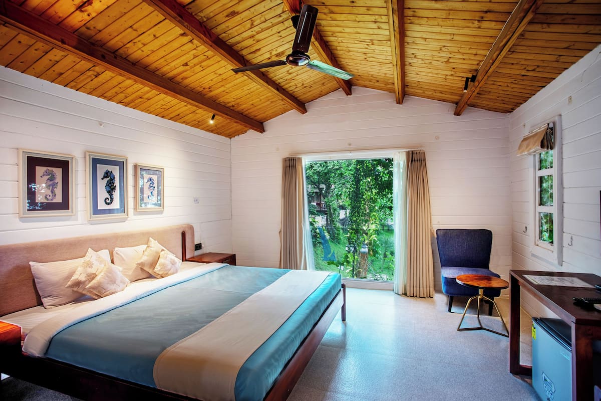 Une chambre à coucher avec un lit, un bureau, une chaise et un ventilateur de plafond.