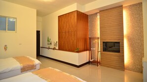A modern hotel room with two beds, a wooden wardrobe, a TV, and a decorative wall. - Fishfun House (Hualien City)