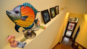 A staircase with a decorative fish sculpture, a figurine, and framed artwork on the wall. - Fishfun House (Hualien City)
