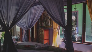 A bedroom with a canopy bed, a view of the outside, and a door leading to another room. - Capung Sakti Villas – By Fair Future Foundation (Ubud)