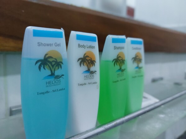 A row of toiletries with labels indicating they are from Helios Beach Resort in Tangalle, Sri Lanka.