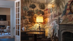 Una habitación amplia con una mesa de comedor, sillas, una lámpara y una chimenea.