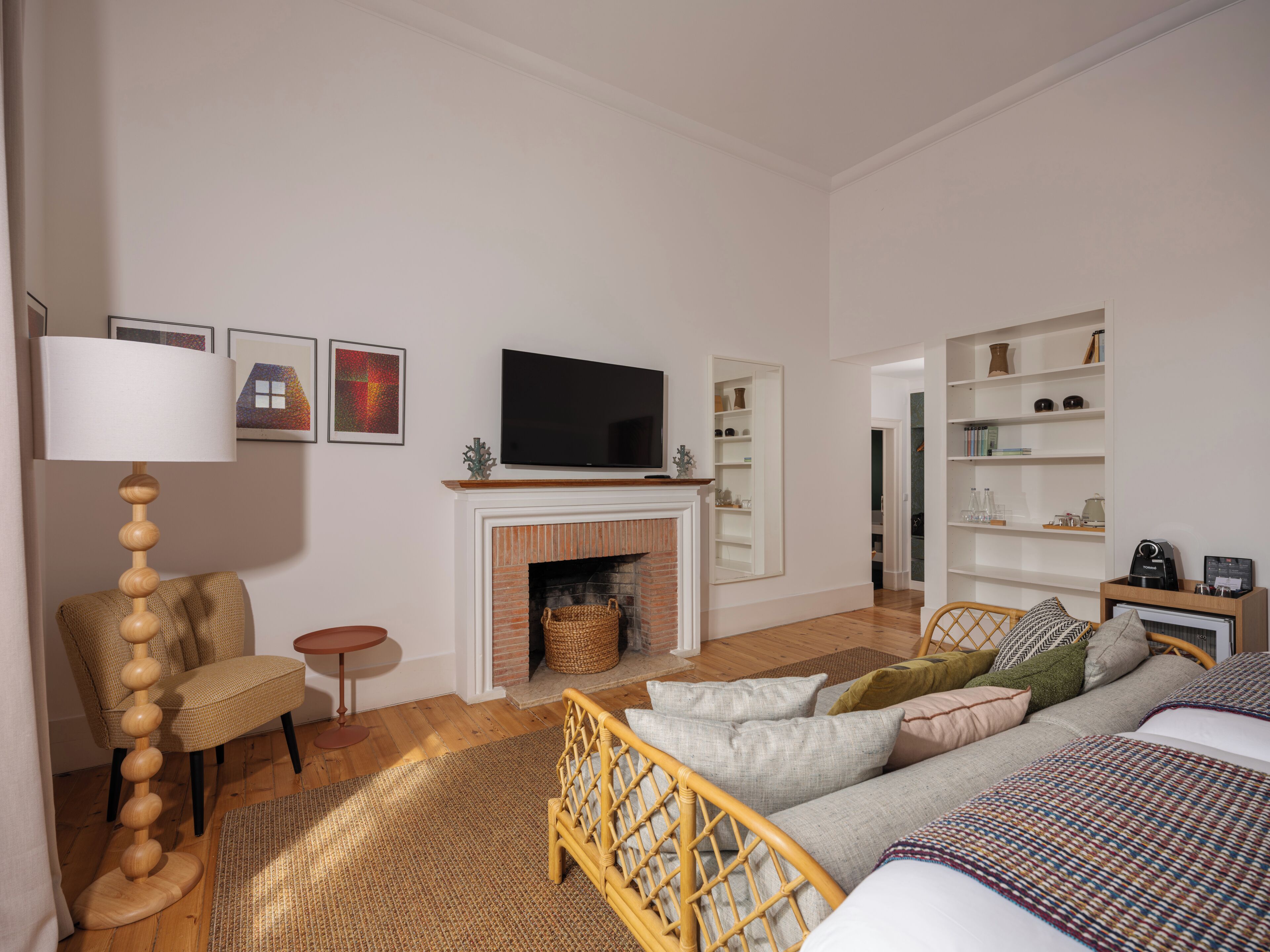A modern living room with a fireplace, a television, a sofa, a chair, and a bookshelf.