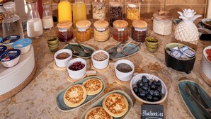Un bufé de desayuno con diversos alimentos y salsas.