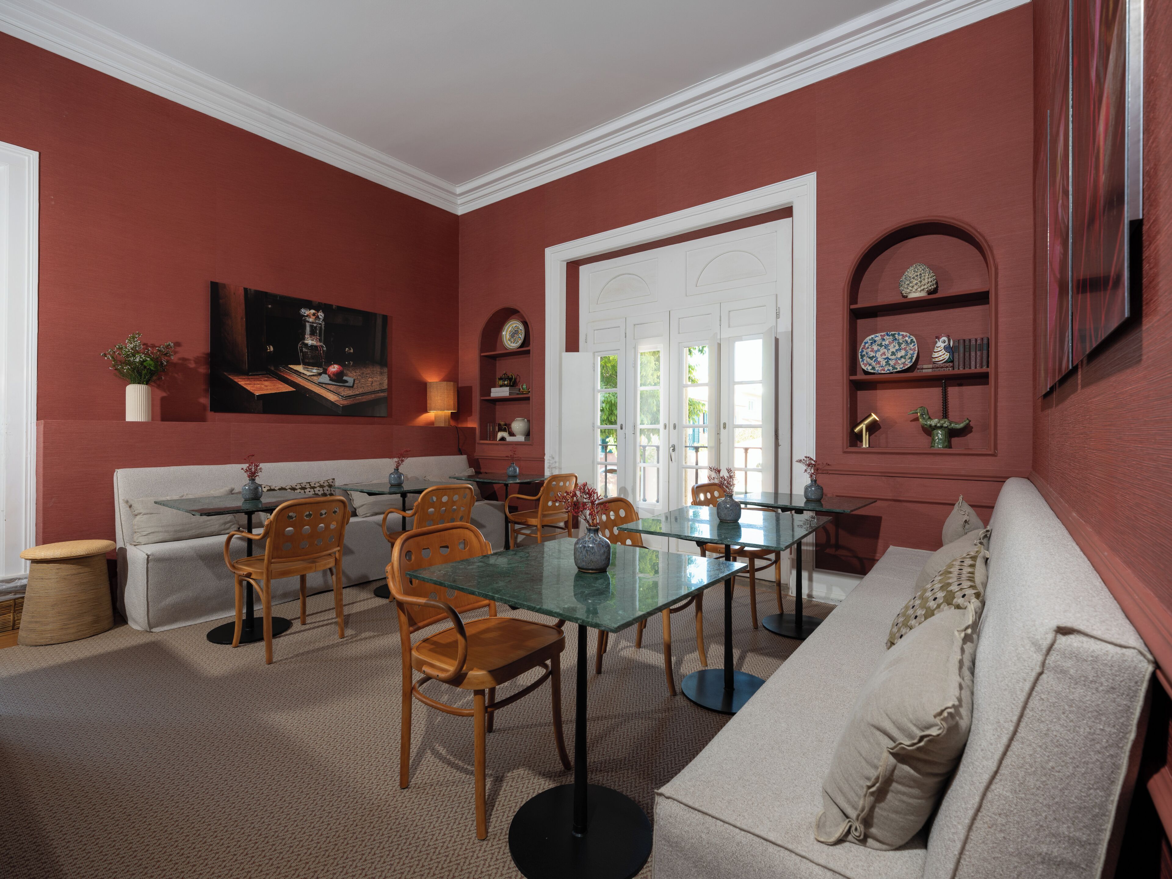 A room with a dining table, chairs, a sofa, and a fireplace.