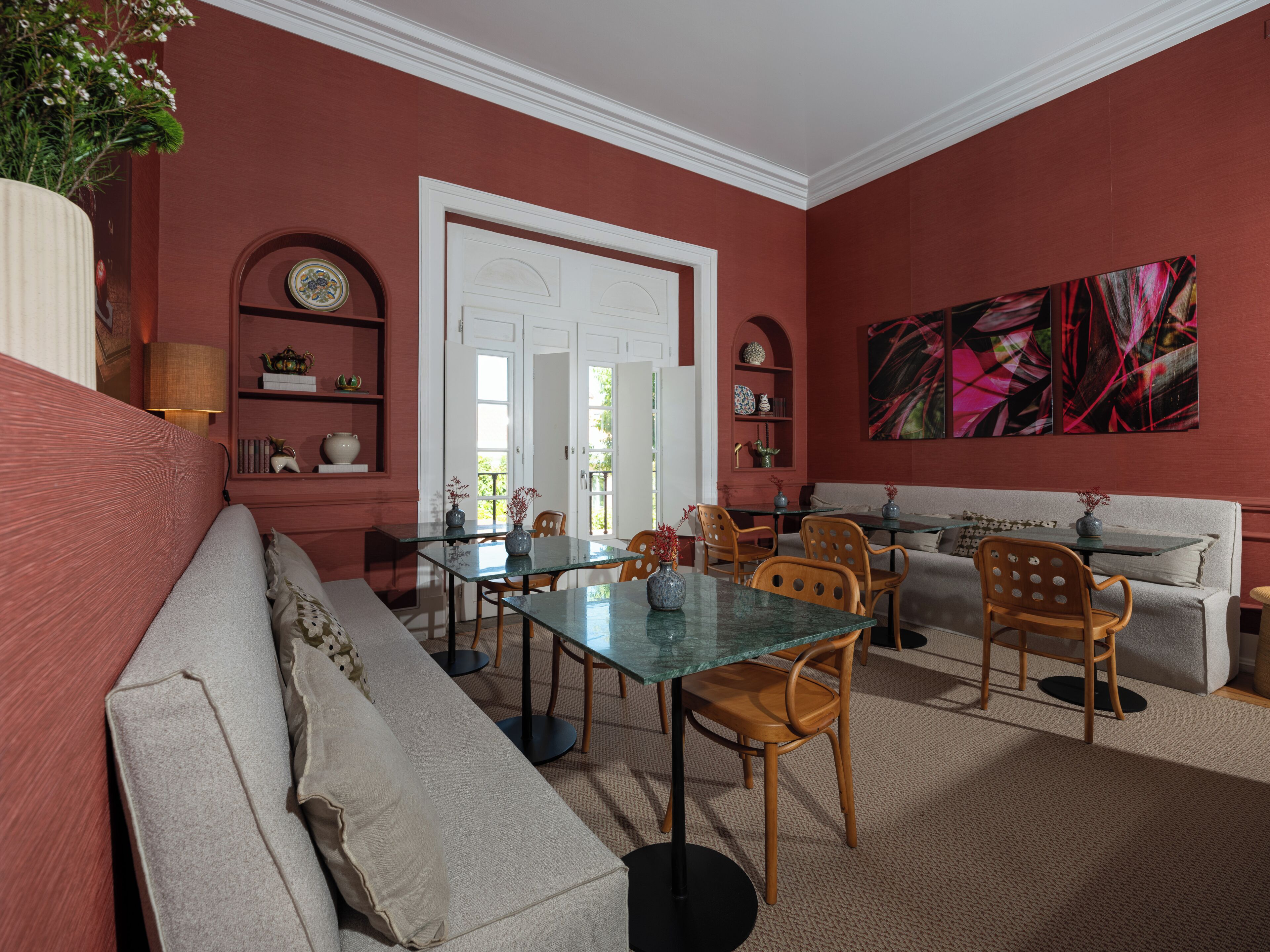 Una habitación con una mesa de comedor, sillas, un sofá, una lámpara y un cuadro.
