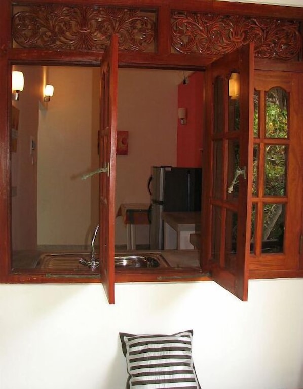 A kitchen with a wooden cabinet, a sink, and a refrigerator. - Unawatuna Apartments (Unawatuna)