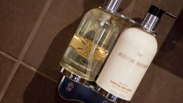 Two bottles of Molton Brown hand wash on a tiled surface.