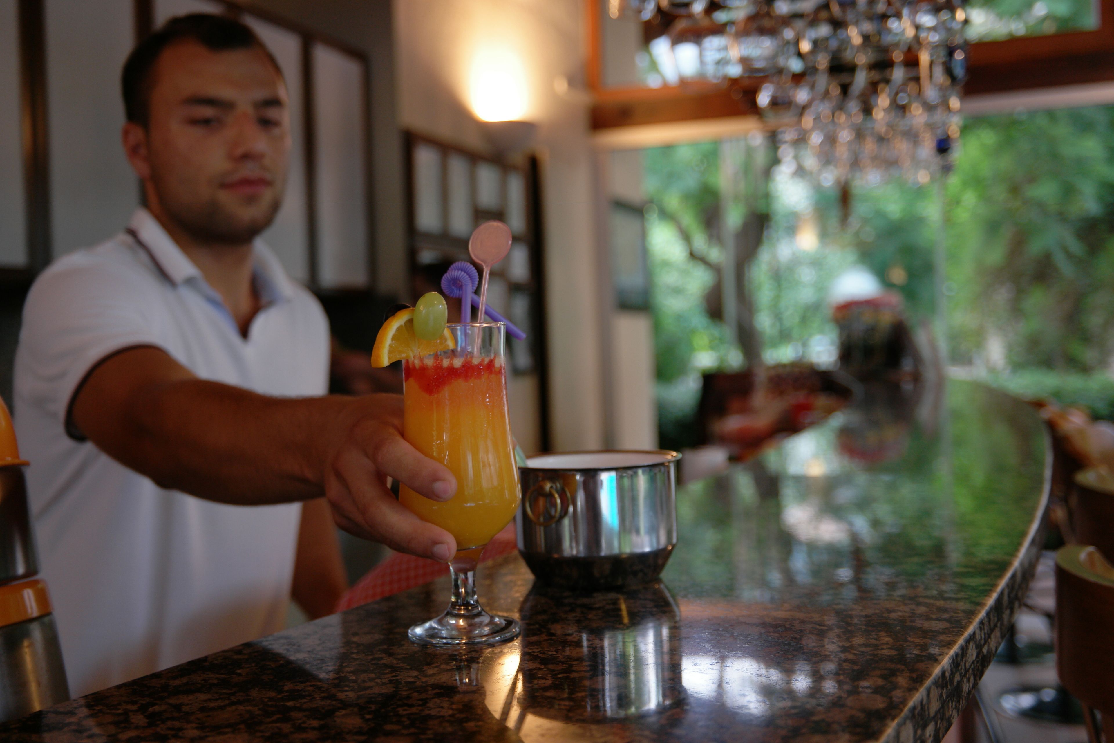 Un bar con un cantinero preparando una bebida.